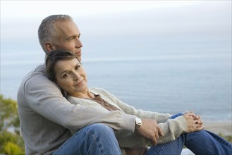 Mature couple embracing on coast