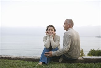 Mature couple sitting on coast