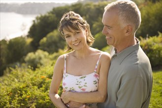 Smiling couple embracing in garden