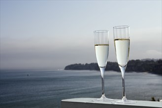 Two glasses of champagne with sea in background