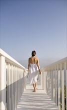 Woman walking on white bridge