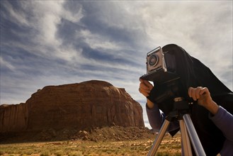 Man photographing desert with vintage camera