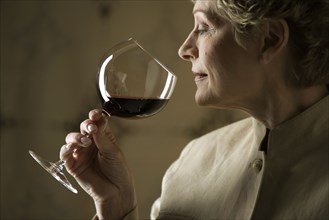 Woman smelling glass of red wine