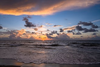 Dramatic sunrise sky above ocean and beach