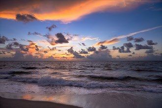 Dramatic sunrise sky above ocean and beach