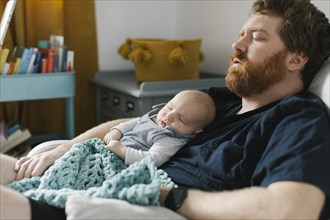 Father sleeping with newborn son
