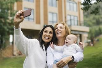 Grandmothers taking selfie with baby grandson
