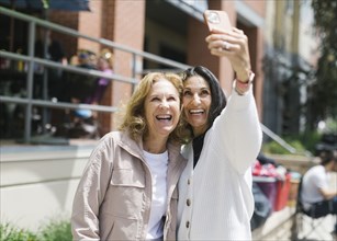 Smiling female friends taking selfie