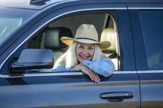 Blonde woman in car wearing cowboy hat