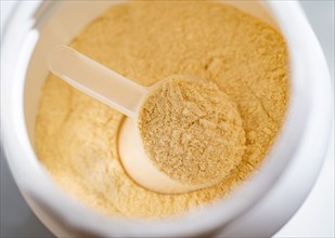 Cup of protein powder in container