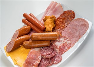 Plate filled with unhealthy processed meats and cheese