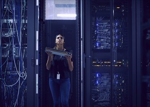 Female technician carrying hard drive in server room