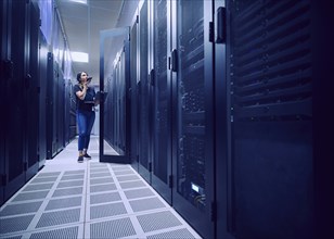 Female technician working in server room