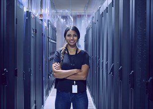 Portrait of smiling female technician standing in server room