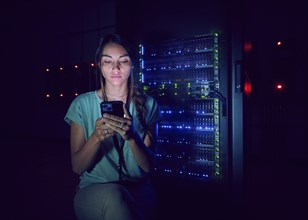 Technician using smart phone in server room