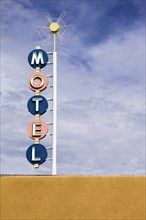 Vintage motel sign against sky