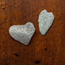 Heart shaped stones on wooden surface
