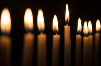 Row of candles against black background