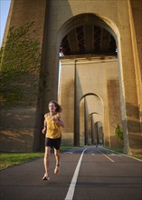 Man jogging under bridge
