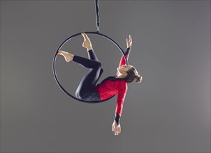 Young acrobat performing on aerial hoop