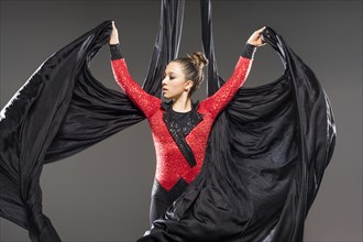Young acrobat performing with aerial silks