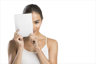 Portrait of woman holding paper in front of face