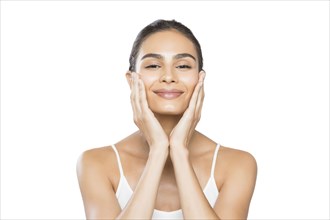 Portrait of smiling young woman doing facial massage