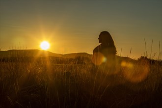 Silhouette of woman enjoying sunset in summer