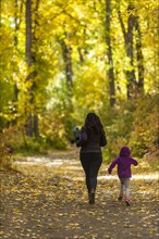 Mother and daughter run through the forest