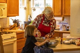 Grandmother and granddaughter bake cookies together