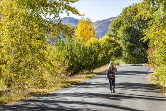 Senior woman walking on country road in fall