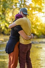 Mid adult couple hugging by river