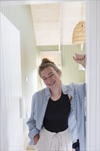 Portrait of teenage girl standing in doorway and smiling