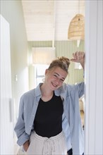 Portrait of teenage girl standing in doorway and smiling