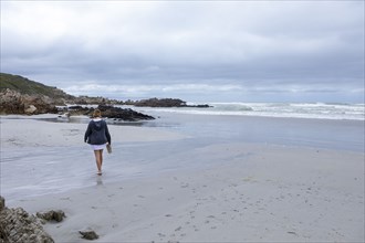 Teenage girl walking on Voelklip beach