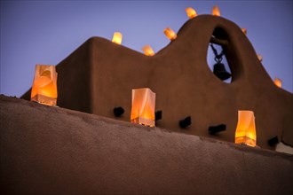 Traditional farolitos lanterns on adobe building