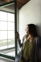 Young woman looking out window