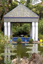 Moroccan tiles roof atop gazebo by tranquil pond