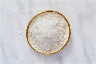 Overhead view of sea salt in bowl on marble surface