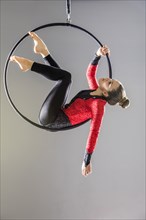 Teenage girl (14-15) practicing aerial dance on gymnastics hoop