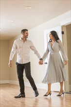 Couple holding hands and walking in to new apartment