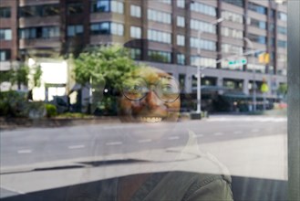 Smiling woman reflected in window in city