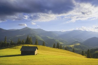 Wooden hut in rural landscape in Carpathian Mountains