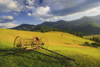 Old farm machine in rural landscape in Carpathian Mountains