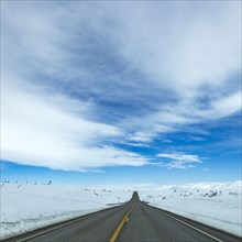 Highway through snow-covered landscape