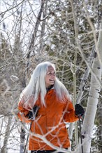 Smiling senior woman snowshoeing in nature