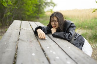 Portrait of teenage girl leaning on picnic table