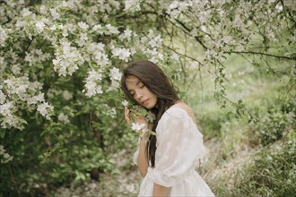 Portrait of teenage girl with blooming apple tree
