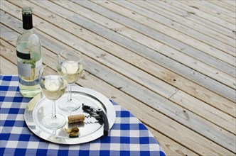White wine bottle and glasses on table outdoors