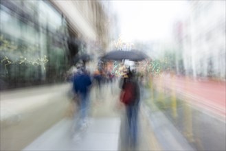 Blurred image of people walking on city street